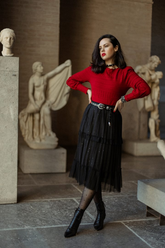 a lady in a red sweater and a black long tulle skirt